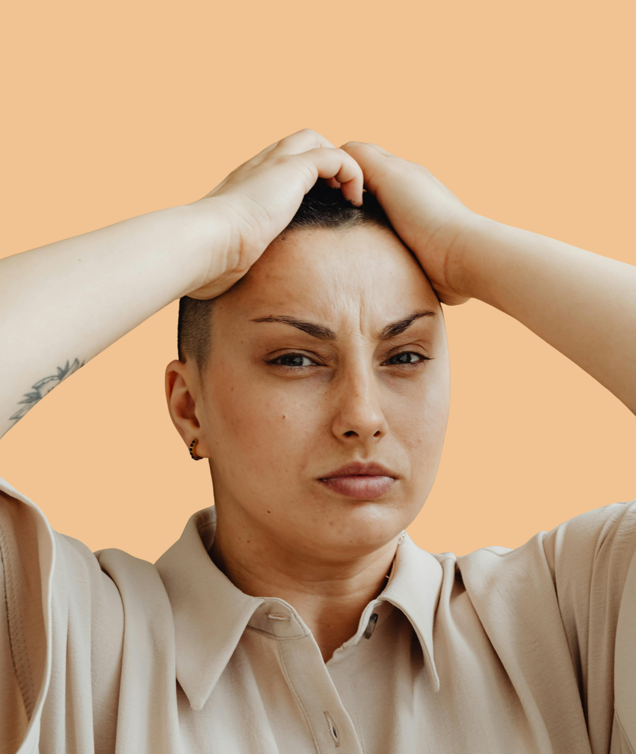 Femme introspective posant la main sur la tête, symbolisant un blocage émotionnel et la pratique EFT